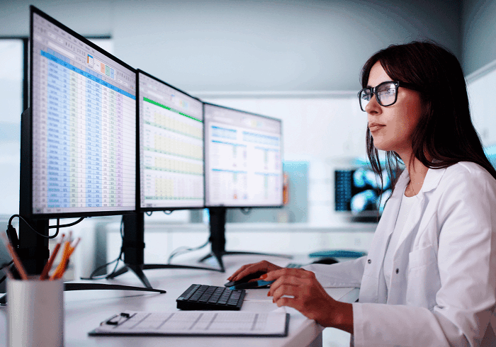Professional reviewing spreadsheets on screens